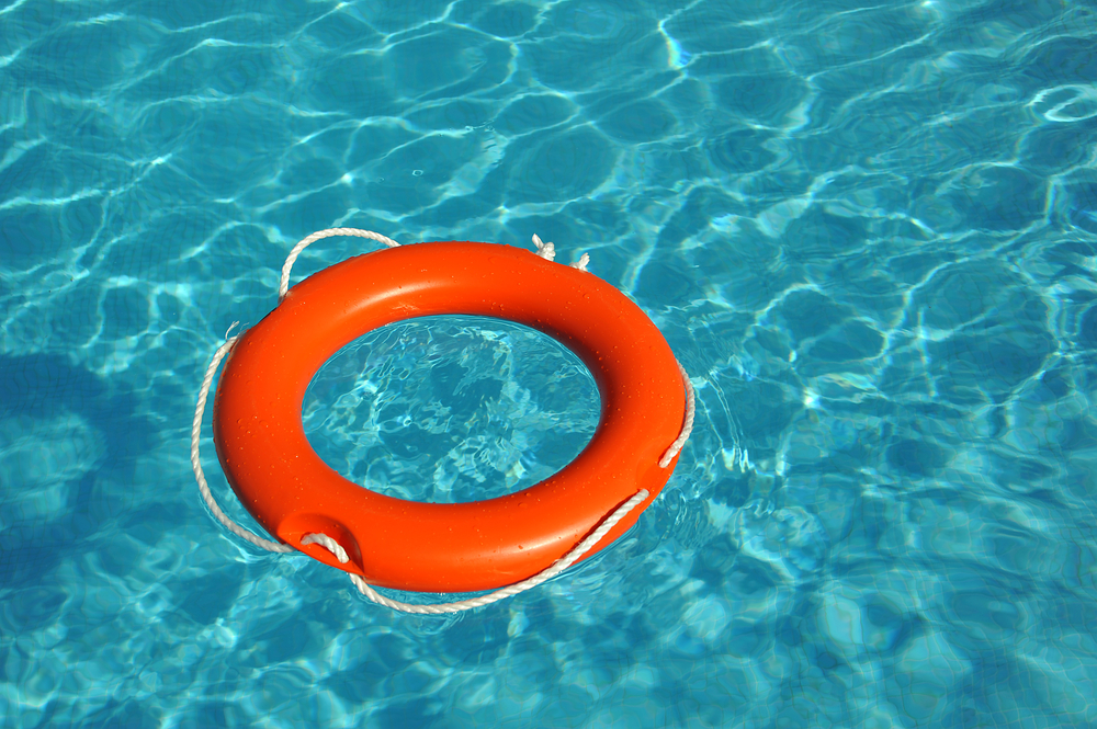 Orange lifebelt floating in blue water