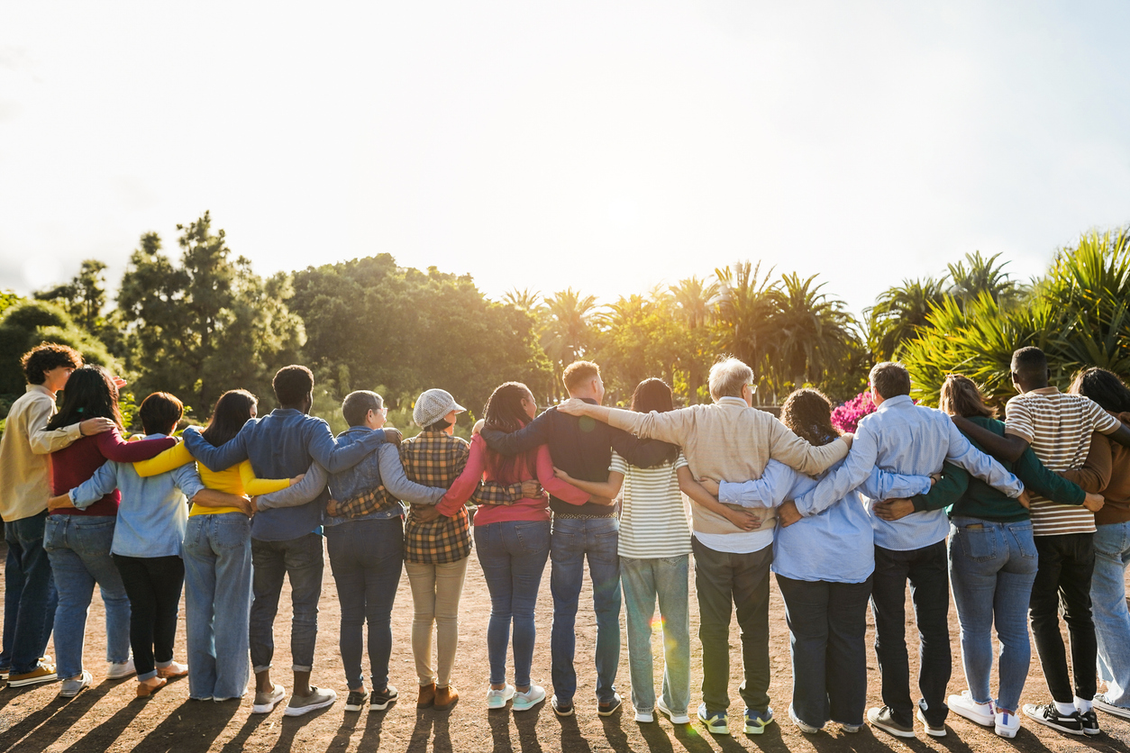 group of multigenerational people hugging each others support, multiracial and diversity concept main focus on senior man with white hairs