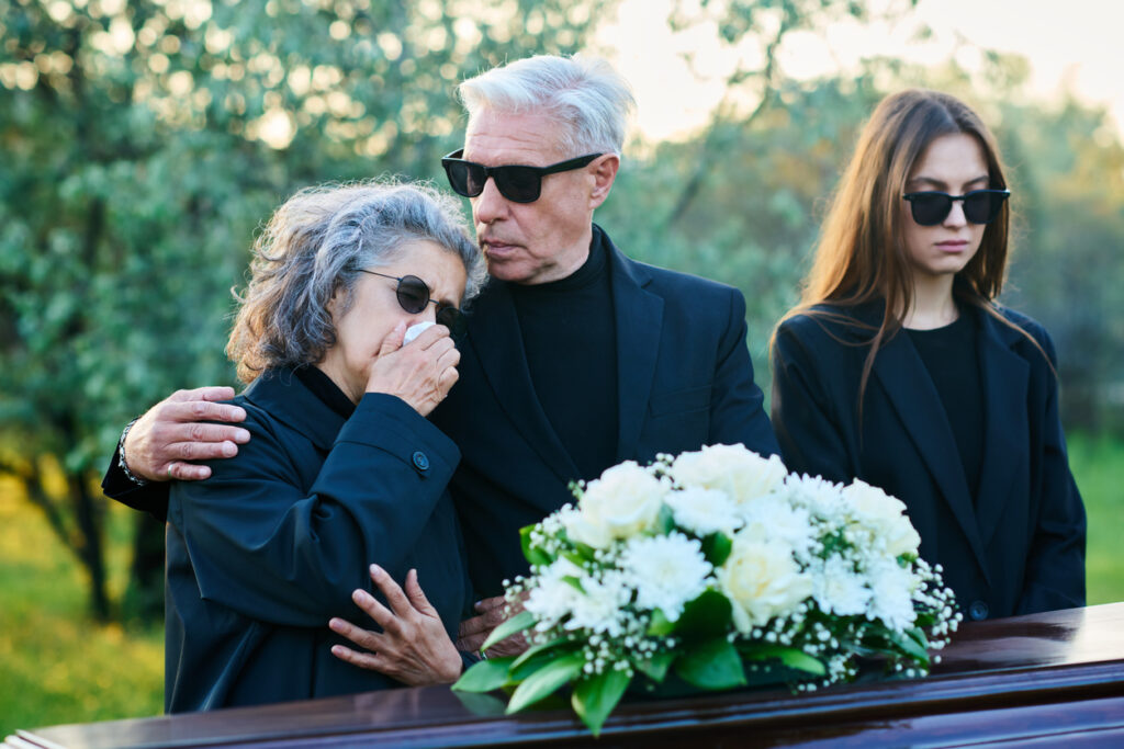 Who can file a wrongful death lawsuit? Man in black attire and sunglasses consoling his wife