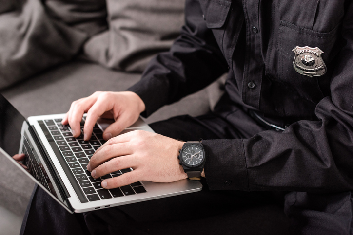 Police officer filing a police report on a laptop - can you claim after a car accident without a police report?